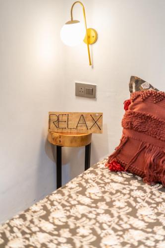 a bed with a table with a sign that says relax at AnandMai Ghar - A Homestay in Gwalior in Gwalior