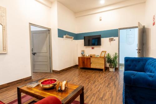 a living room with a blue couch and a table at AnandMai Ghar - A Homestay in Gwalior in Gwalior