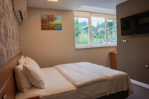 a small bedroom with a bed and a window at The MU City Hotel Trabzon in Trabzon