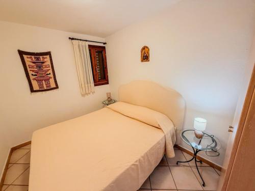 a small bedroom with a bed and a table at Casa Puni Porto Rotondo in Porto Rotondo
