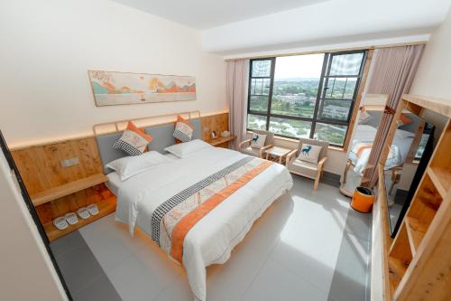 a bedroom with a bed and a large window at Huimu Mansion - Tianmenshan Branch in Xixiping