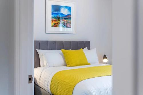 a bedroom with a bed with a yellow blanket at Morden 2BR Apt with city views in Manchester