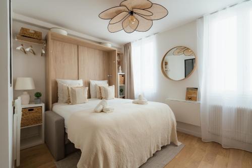 une chambre avec un grand lit blanc avec un ventilateur de plafond dans l'établissement Cosy studio près du Panthéon, à Paris