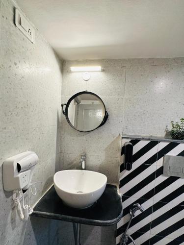 a bathroom with a white sink and a mirror at AnandMai Ghar - A Homestay in Gwalior in Gwalior