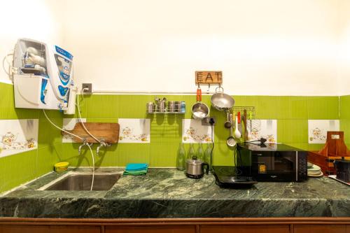 a kitchen with a sink and a microwave at AnandMai Ghar - A Homestay in Gwalior in Gwalior