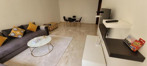 a living room with a couch and a table at Apartment Close to Casablanca Mohamed V Airport in Nouaseur