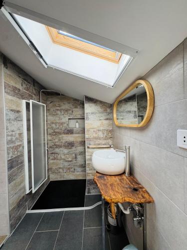 a bathroom with a sink and a skylight at Vila Eruga- Apartament 3 in Poiana Mărului