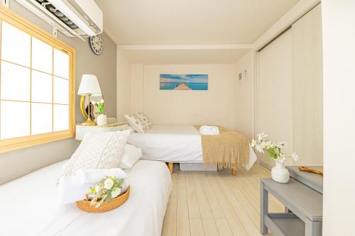 a hotel room with two beds and a window at KOSUMOSU Ikebukuro Shinjuku Private House in Tokyo