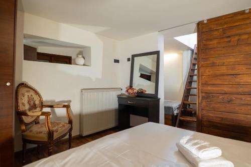 a bedroom with a bed and a chair and a mirror at Villa Stagiates in Stagiates