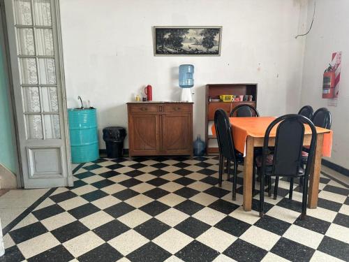 a dining room with a table and chairs on a checkered floor at Chandra Multiespacio in Gualeguaychú