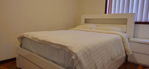 a white bed in a room with a window at Entire 3 bedroom personal house in Chipping Norton in Chipping Norton