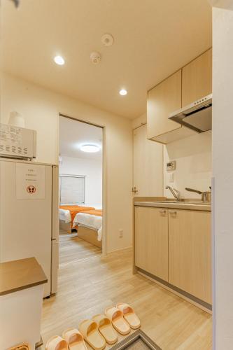 a kitchen with a sink and a room with a bed at KOSUMOSU Ikebukuro Shinjuku Private House in Tokyo
