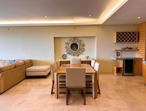 a dining room with a table and a couch at ANANA El Dorado 305 | Pool & Lake Views in Ajijic