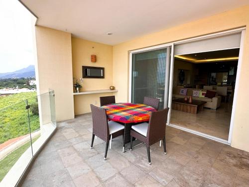 a patio with a table and chairs on a balcony at ANANA El Dorado 305 | Pool & Lake Views in Ajijic