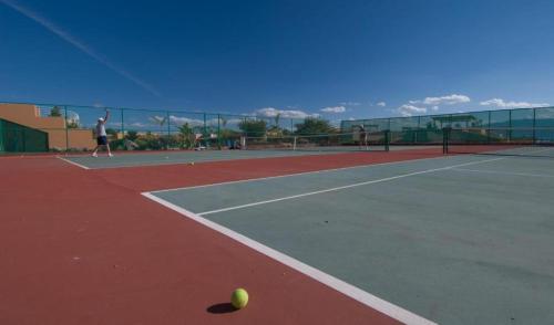 a person playing tennis on a tennis court at ANANA El Dorado 305 | Pool & Lake Views in Ajijic