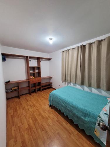 ein Schlafzimmer mit einem Bett, einer Kommode und einem Fenster in der Unterkunft Departamento cerca del aeropuerto in Lima