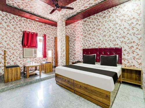 a bedroom with a bed and a red wall at Hotel O Astoria in Zirakpur