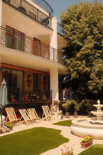 a group of lawn chairs in front of a building at Mood Hotel Kazbegi in Stepantsminda