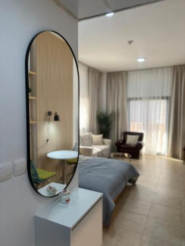 a bedroom with a bed and a mirror on the wall at Lovely Studio with balcony in Silicon Oasis in Dubai