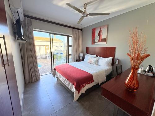 a bedroom with a bed with a red blanket at Le Blue Guesthouse in Port Elizabeth