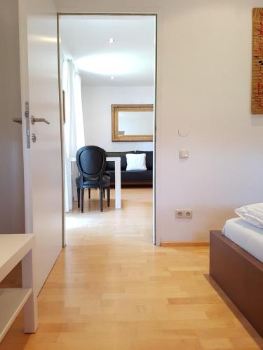 a bedroom with a mirror and a black chair at Reschbergerhof Appartements by Geierspichler in Anif