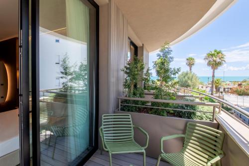 two chairs on a balcony with a view of the ocean at International Hotel & Suite in San Benedetto del Tronto