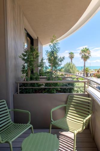 two chairs on a balcony with a view of the ocean at International Hotel & Suite in San Benedetto del Tronto