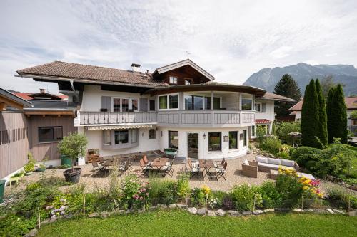 a large white house with a patio and a yard at Alma Hotel Oberstdorf in Oberstdorf