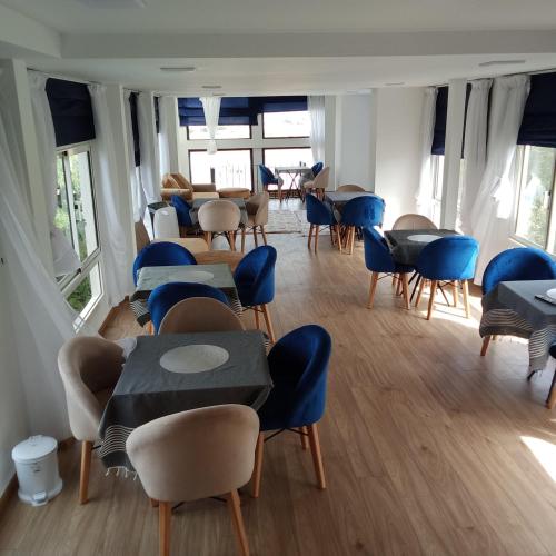 a room with blue chairs and tables and windows at MDE Loisir Tanjis m in Tangier