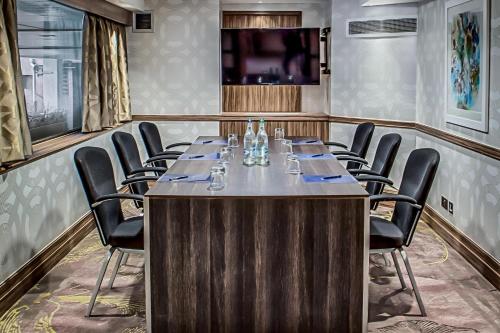 a conference room with a long table and chairs at Hilton London Kensington Hotel in London