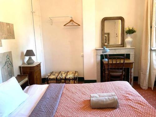 a bedroom with a bed and a table and a mirror at Villa Magdala Arts & Résidence in Hyères