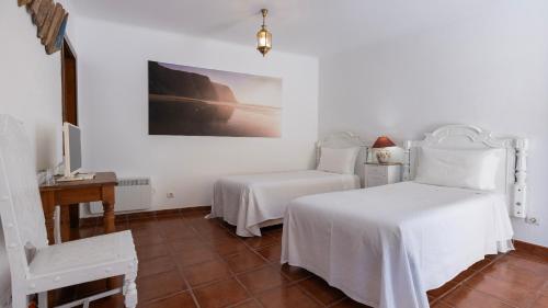 a bedroom with two beds and a table and a desk at Vinha da Quinta in Sintra