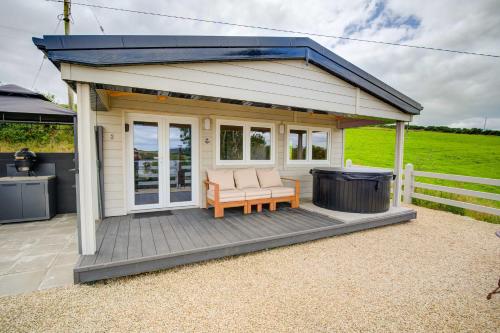 a shed with a grill and a bench on a deck at Luxury Log Cabin with Private Hot Tub & Sea Views in Letterkenny