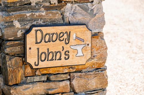 a sign on the side of a stone wall at Luxury Log Cabin with Private Hot Tub & Sea Views in Letterkenny