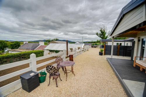 two chairs sitting on the porch of a house at Luxury Log Cabin with Private Hot Tub & Sea Views in Letterkenny