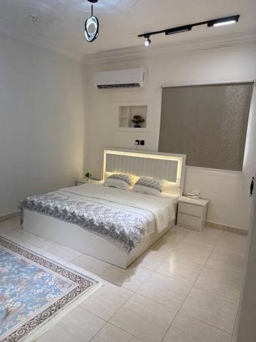 a white bedroom with a bed and a chalkboard at قصر الضيافه in Al Madinah