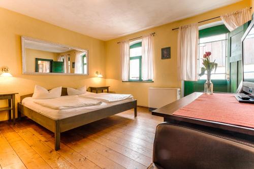 1 dormitorio con cama, escritorio y mesa en Pension Rauschenstein, en Bad Schandau