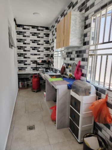 a kitchen with black and white tiles on the wall at Happy Home in Kuala Kubu Baharu