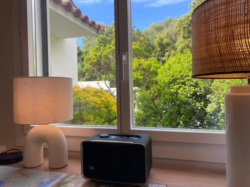 a room with two lamps and a suitcase in front of a window at Villa and independent studio St Raphaël Agay in Saint-Raphaël