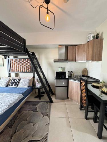 a bedroom with a bunk bed and a kitchen at Tagaytay Staycation with Great Location in Tagaytay