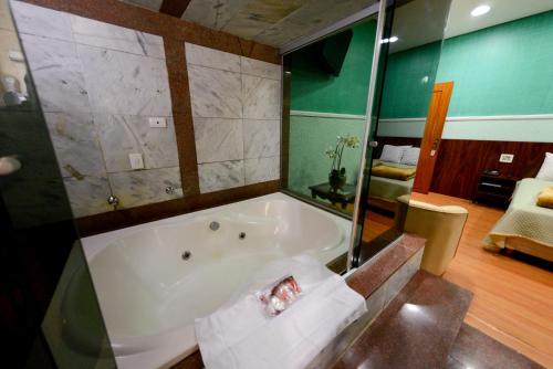 a bathroom with a bath tub in a room at Estoril Palace Hotel in Registro