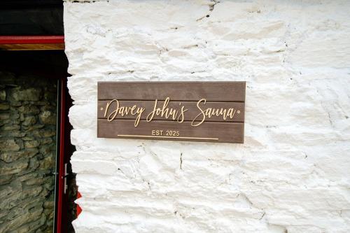 a sign on the side of a stone wall at Luxury Log Cabin with Private Hot Tub & Sea Views in Letterkenny