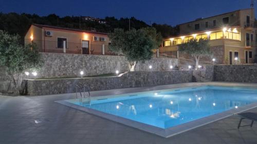 a swimming pool in front of a building at night at La Valle degli Ulivi in Acquedolci