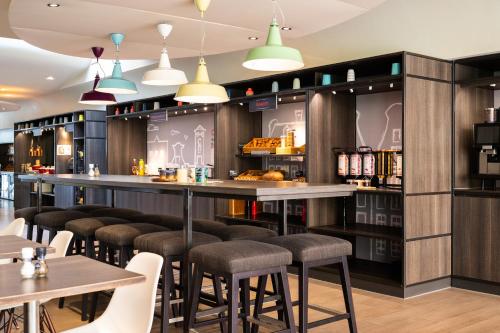 a bar with stools and tables in a restaurant at ibis Amsterdam Centre Stopera in Amsterdam