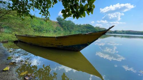 a wooden boat sitting on the shore of a lake at Nyanja View Resort in Fort Portal