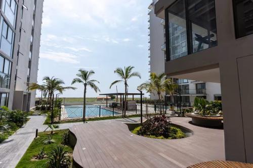a view of a building with a pool and palm trees at Luxury vacation apartment, sea salt flats in Playa Bello Horizonte