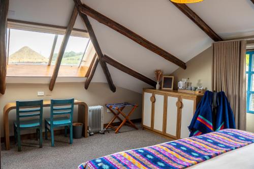 a bedroom with a bed and a table and chairs at Hacienda El Porvenir by Tierra del Volcan in Machachi