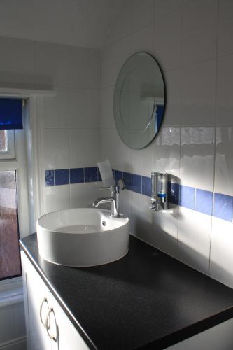 Un baño con un lavabo y un espejo sobre un mostrador. en The Meltham Guesthouse Scarborough, en Scarborough