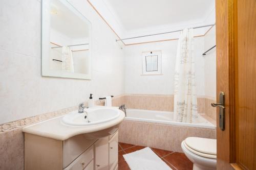 a bathroom with a sink and a toilet and a tub at Casa Amendoeira Large Private Pool WiFi in Albufeira