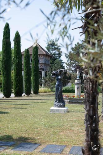 a statue in the middle of a garden with a building at Les Saules Parc & Spa - Teritoria in Vonnas